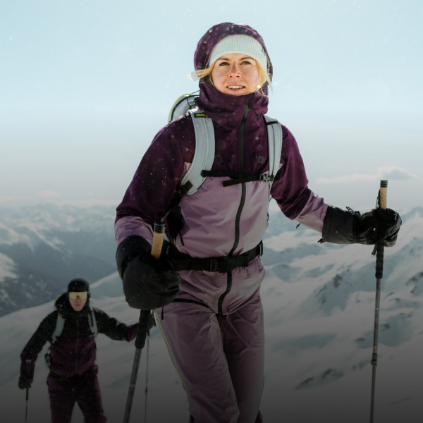 Frau auf Skiern in schneebedeckten Bergen.