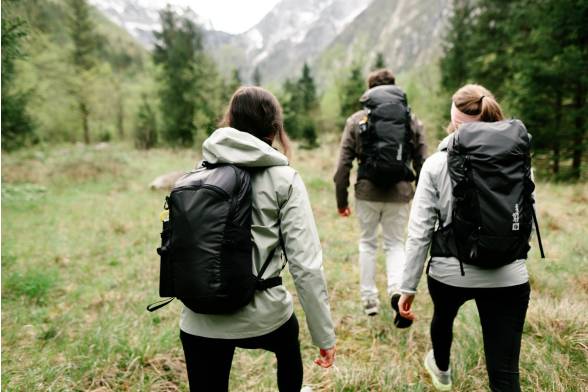 Ripresa di tre zaini da trekking di tre escursionisti con un look sportivo da dietro