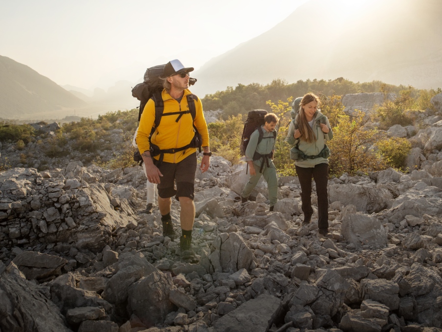 Tre escursionisti con attrezzatura da trekking in montagna