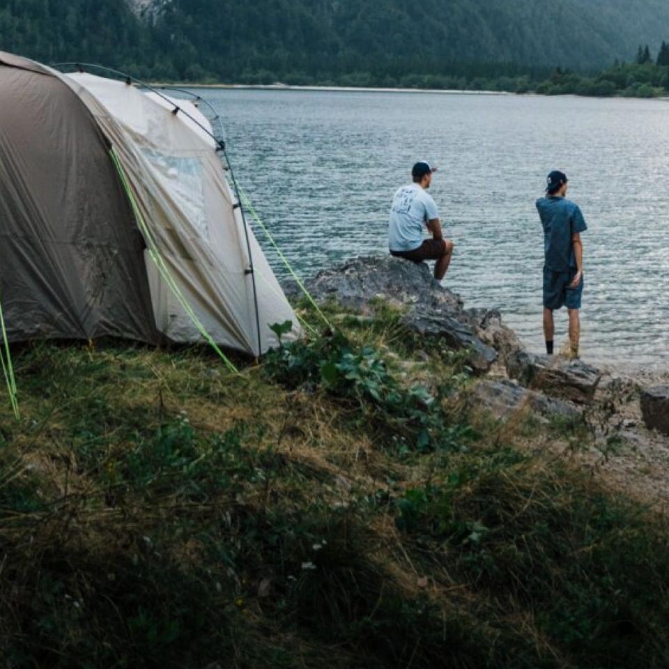 Due persone sdraiate in una tenda che unendo le loro mani formano un cuore